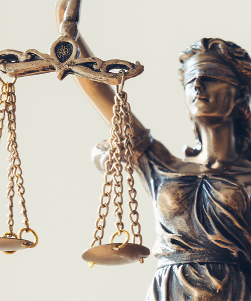 A statue of Lady Justice, blindfolded, holding a balanced scale, symbolizing fairness and impartiality in law.